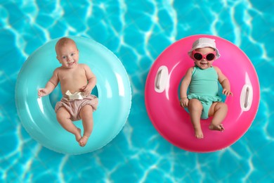 Image of Cute little babies with inflatable rings in swimming pool, top view