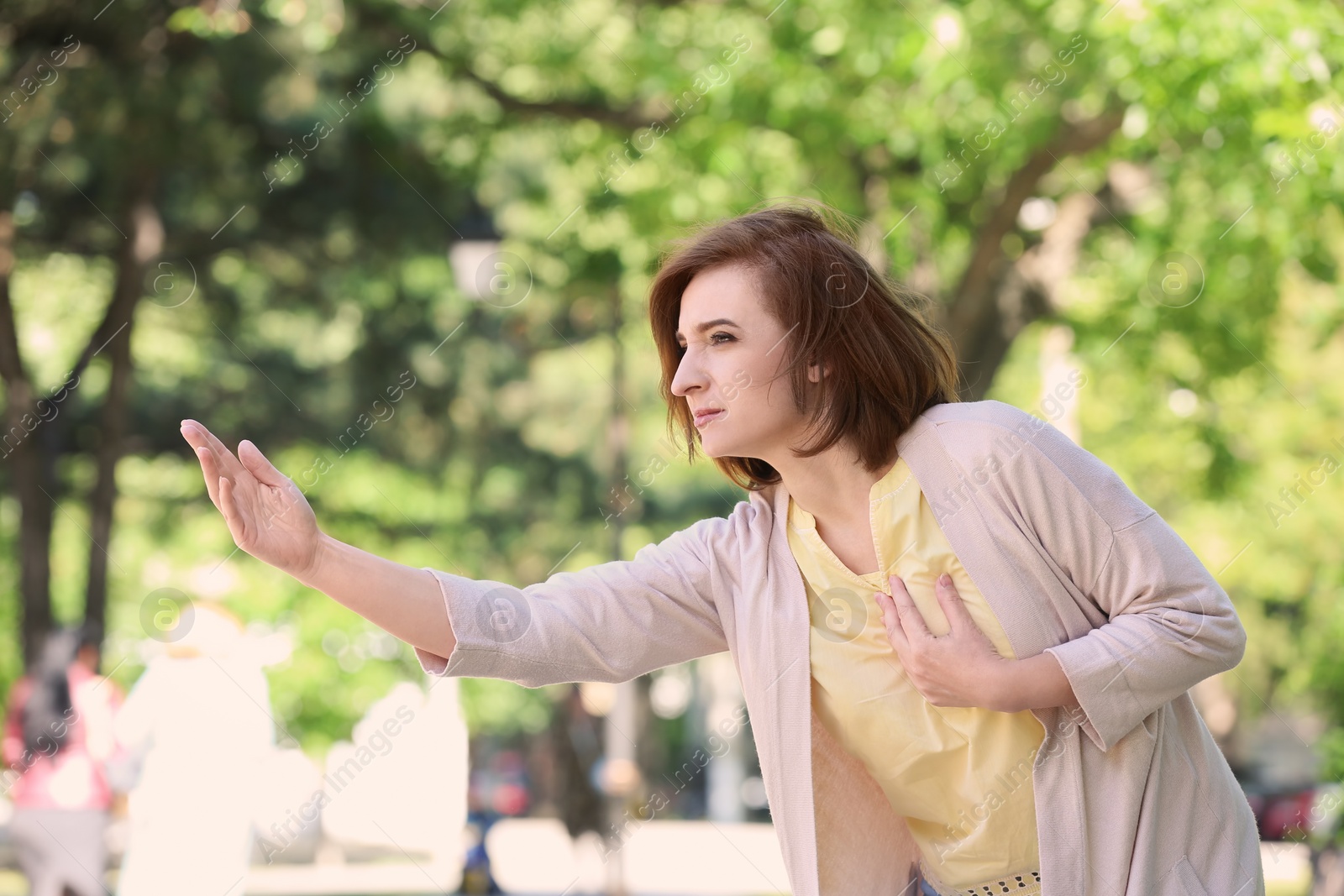 Photo of Mature woman having heart attack, outdoors