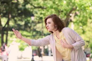 Photo of Mature woman having heart attack, outdoors