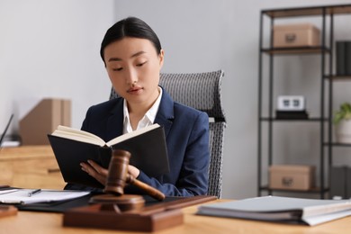 Notary reading book at table in office