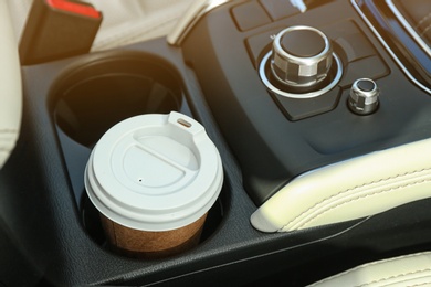 Photo of Takeaway paper coffee cup in holder inside car