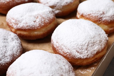 Delicious buns with powdered sugar in box, closeup