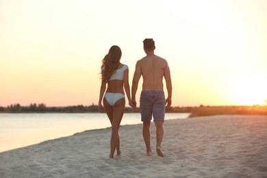 Photo of Happy young couple walking together on beach