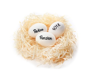 Photo of Eggs with words PENSION, RETIRE and 401k in nest on white background