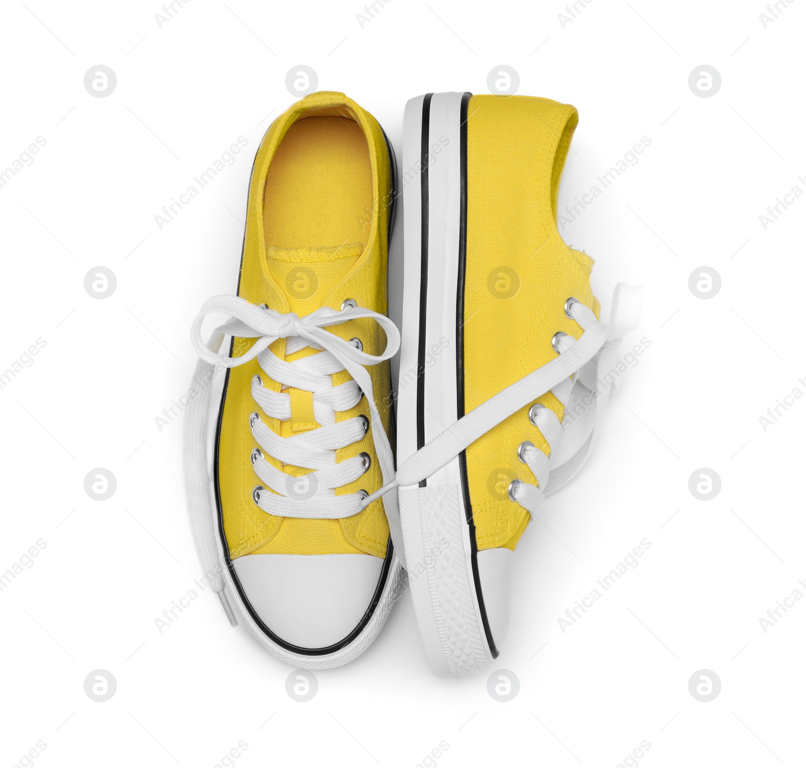 Photo of Pair of yellow classic old school sneakers isolated on white, top view