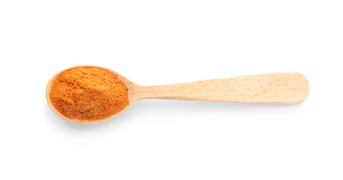 Photo of Wooden spoon with red pepper powder on white background, top view