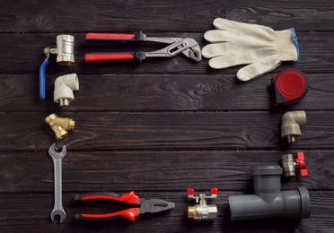 Photo of Flat lay composition with plumber's tools and space for text on wooden background