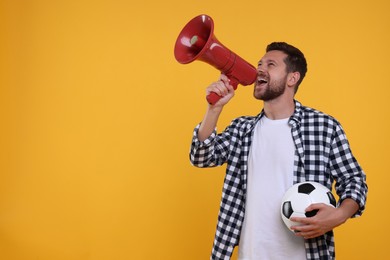 Emotional sports fan with ball and megaphone on yellow background. Space for text