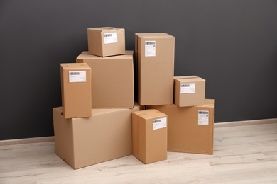 Stacked parcel boxes on floor against grey wall