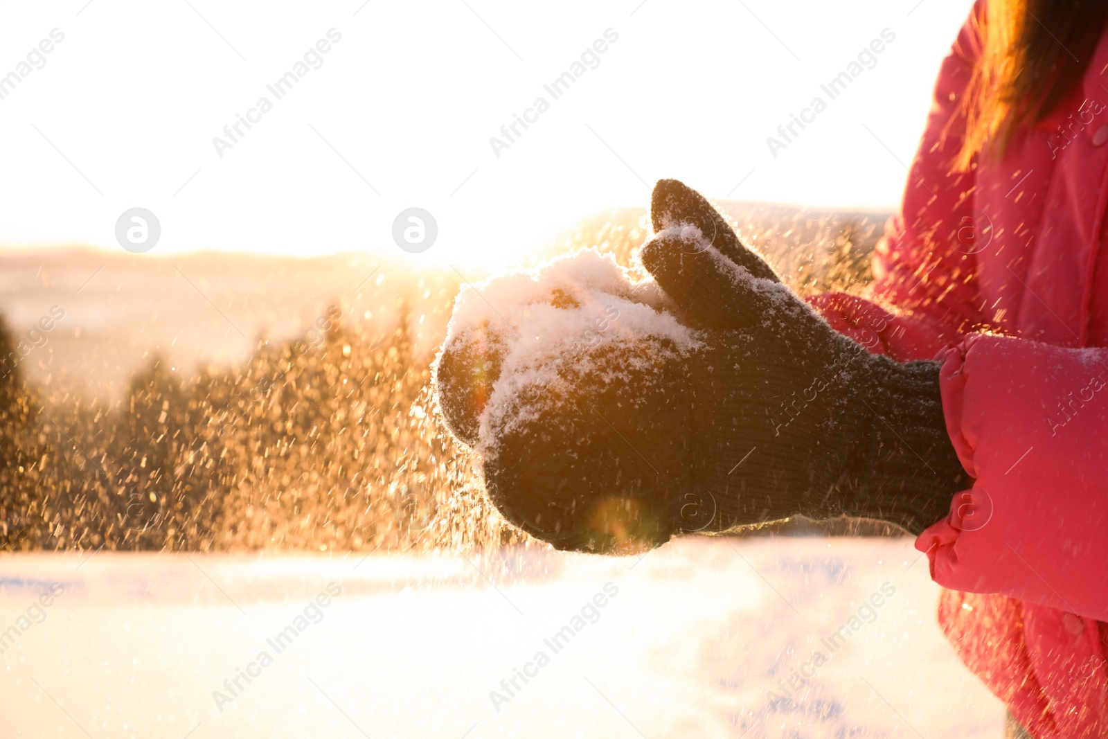 Photo of Woman holding pile of snow outdoors, closeup. Winter vacation