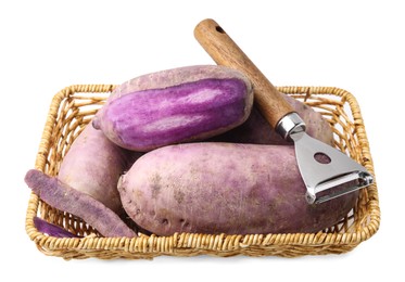 Photo of Purple daikon radishes and peeler in wicker basket isolated on white