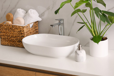 Stylish vessel sink on light countertop in modern bathroom