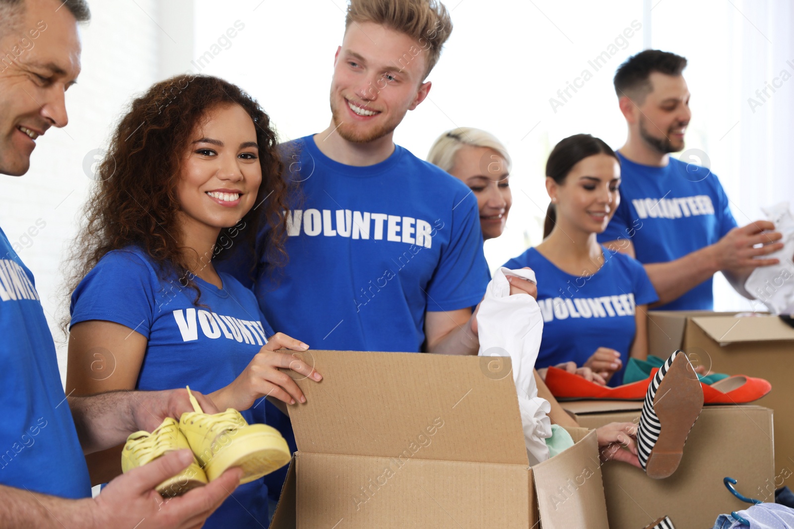 Photo of Team of volunteers collecting donations in boxes indoors