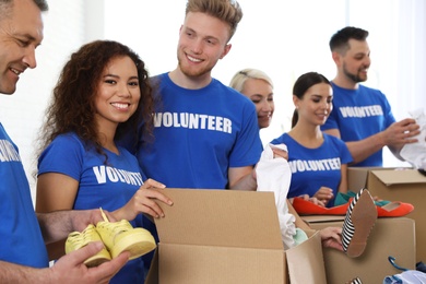 Photo of Team of volunteers collecting donations in boxes indoors