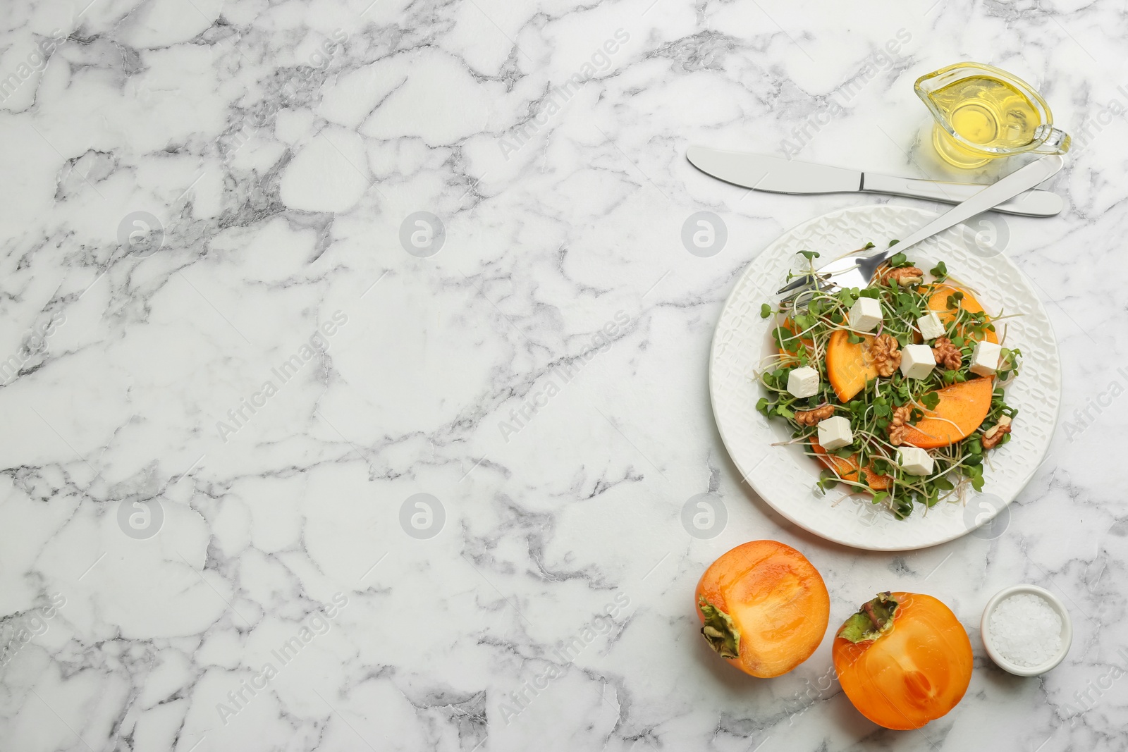 Photo of Delicious persimmon salad served on white marble table, flat lay. Space for text