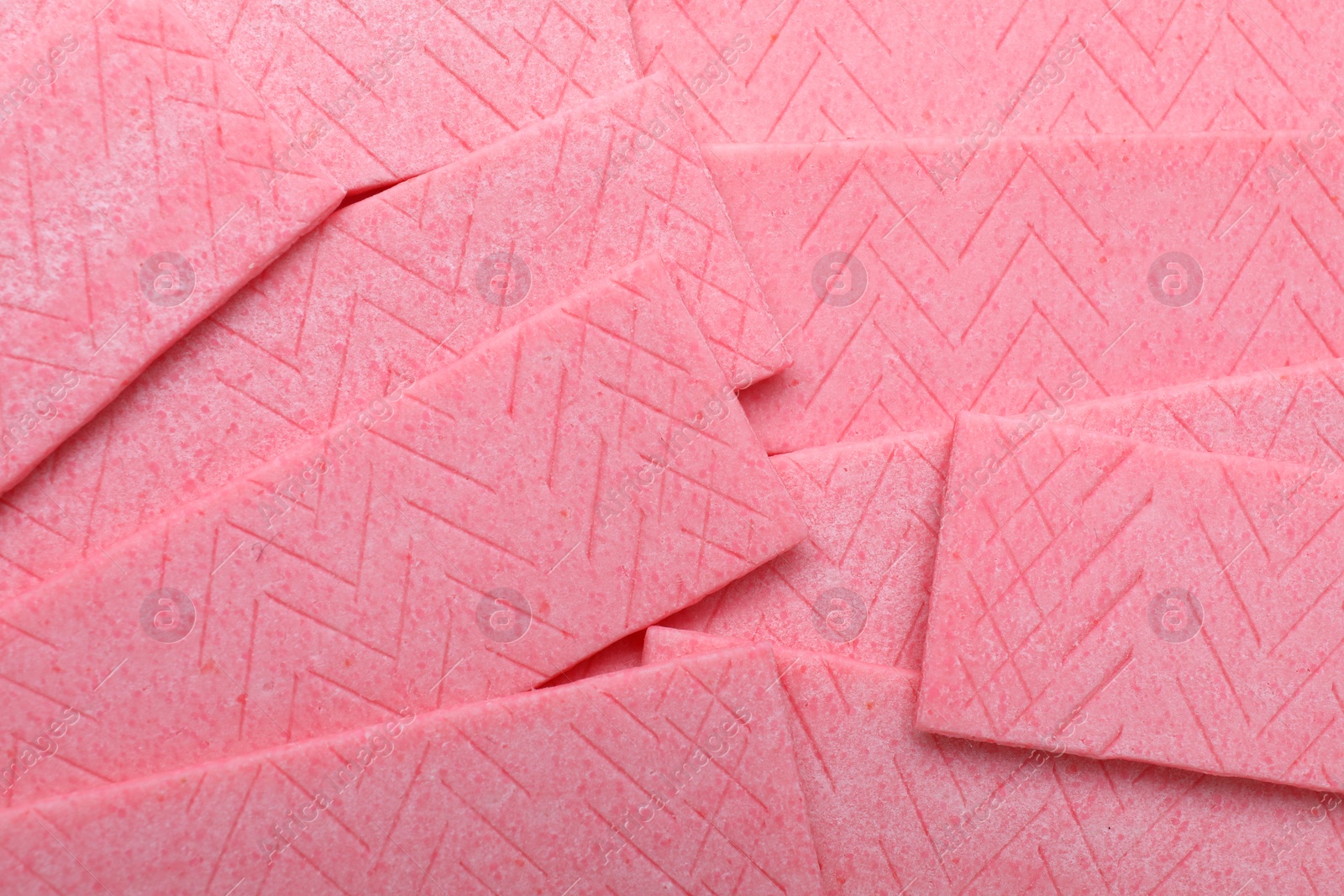 Photo of Sticks of pink chewing gum as background, top view