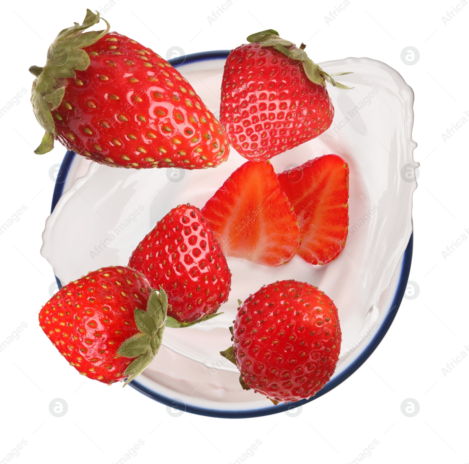 Image of Delicious ripe strawberries falling into bowl with yogurt on white background, top view