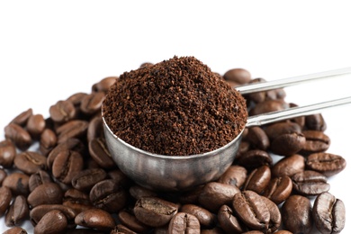 Scoop with coffee grounds and roasted beans on white background, closeup