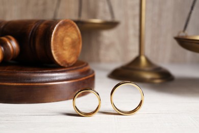 Photo of Divorce concept. Wedding rings on white wooden table, closeup with space for text