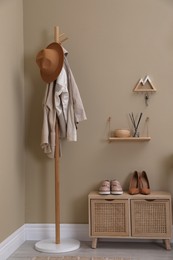 Photo of Modern hallway interior with stylish furniture and wooden hanger for keys on beige wall