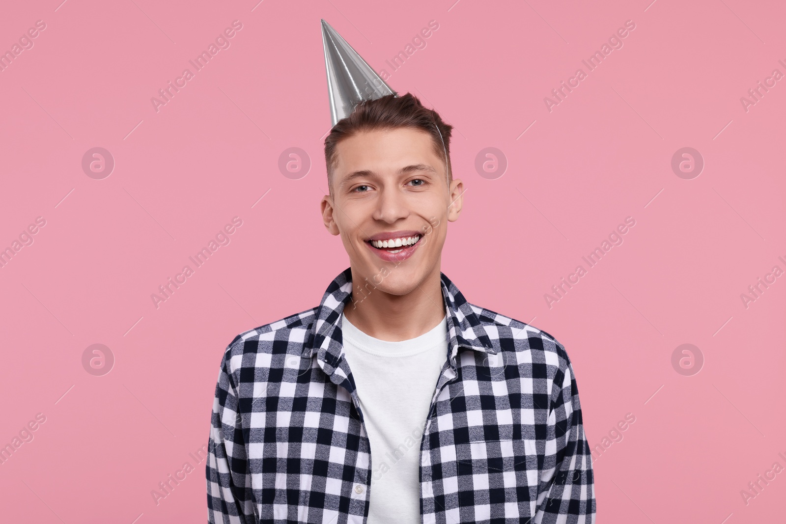 Photo of Happy man in party hat on pink background