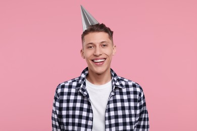 Photo of Happy man in party hat on pink background