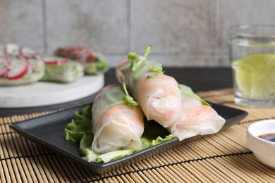 Photo of Delicious spring rolls wrapped in rice paper on table