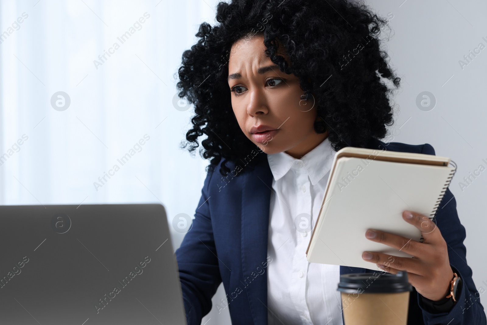 Photo of Deadline concept. Emotional woman looking at laptop and holding notepad in office