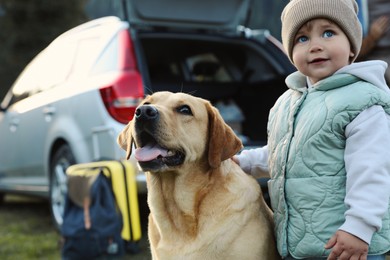 Photo of Cute kid and dog outdoors. Family traveling with pet