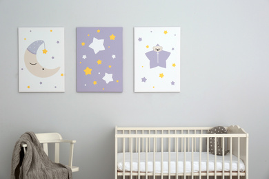 Photo of Baby room interior with crib and cute posters on wall