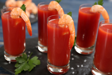 Photo of Shrimp cocktail with tomato sauce served on slate board