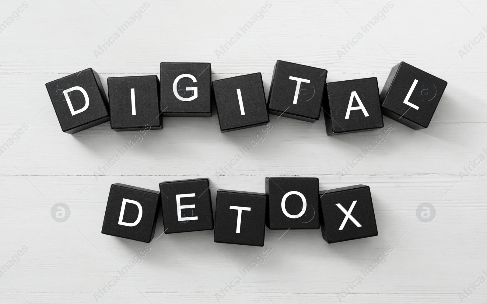 Photo of Black cubes with words DIGITAL DETOX on white wooden background, flat lay