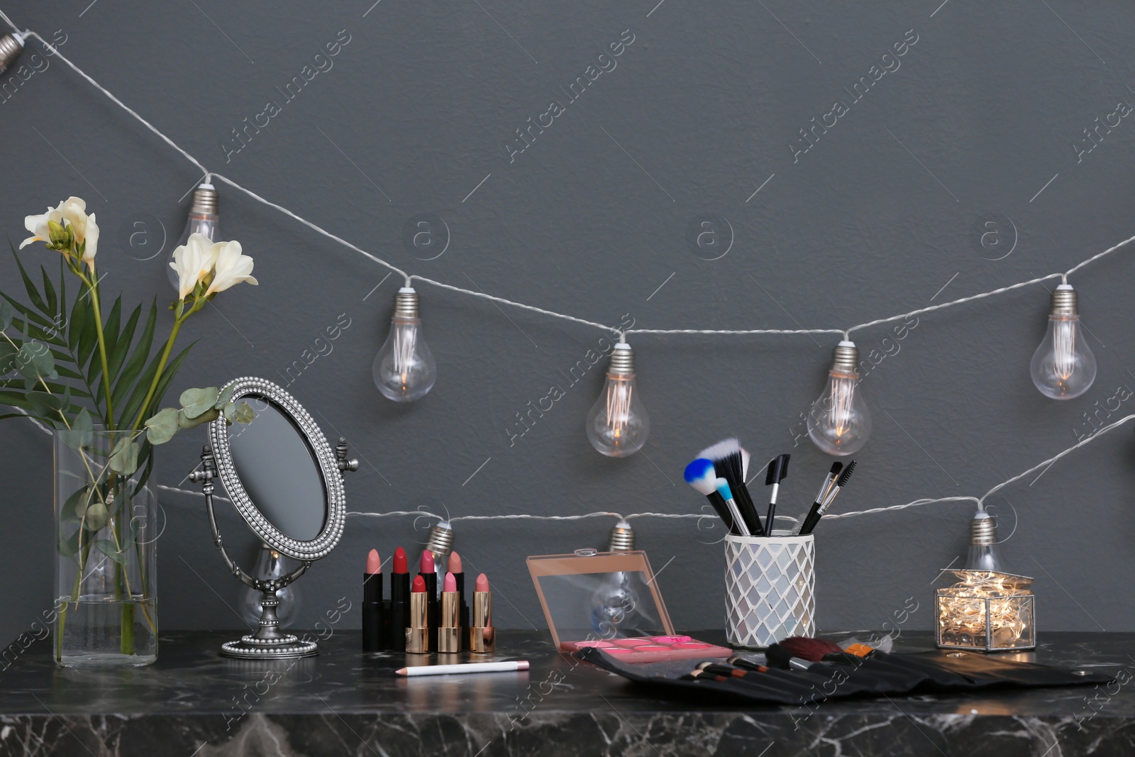 Photo of Decorative cosmetics and tools on dressing table in makeup room