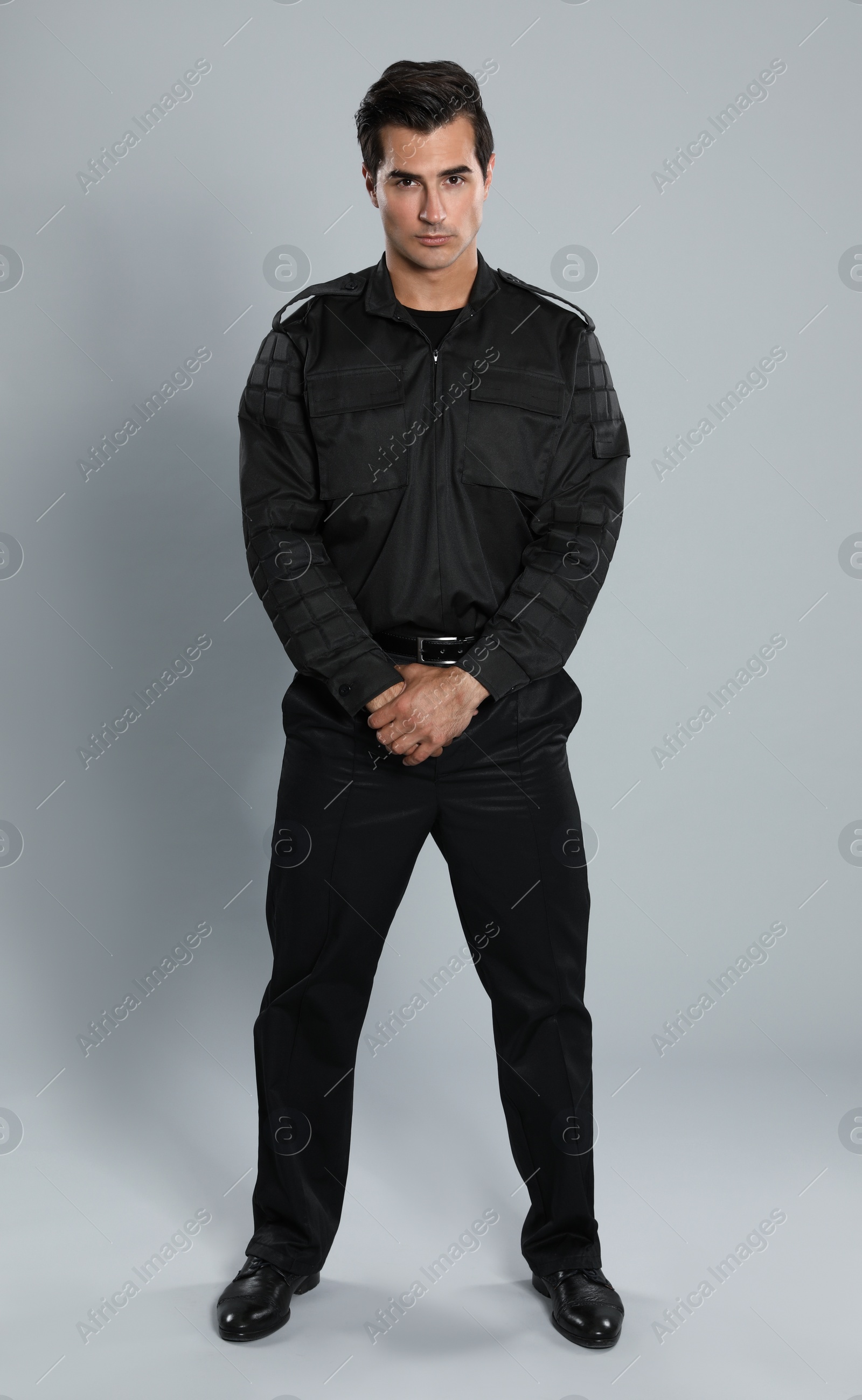 Photo of Male security guard in uniform on grey background