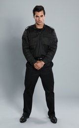 Photo of Male security guard in uniform on grey background