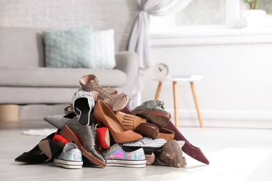 Photo of Pile of female shoes on floor indoors. Space for text