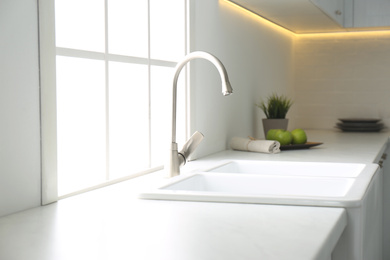 Photo of New ceramic sink and modern tap in stylish kitchen interior