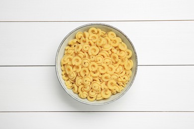 Raw dischi volanti pasta in bowl on white wooden table, top view