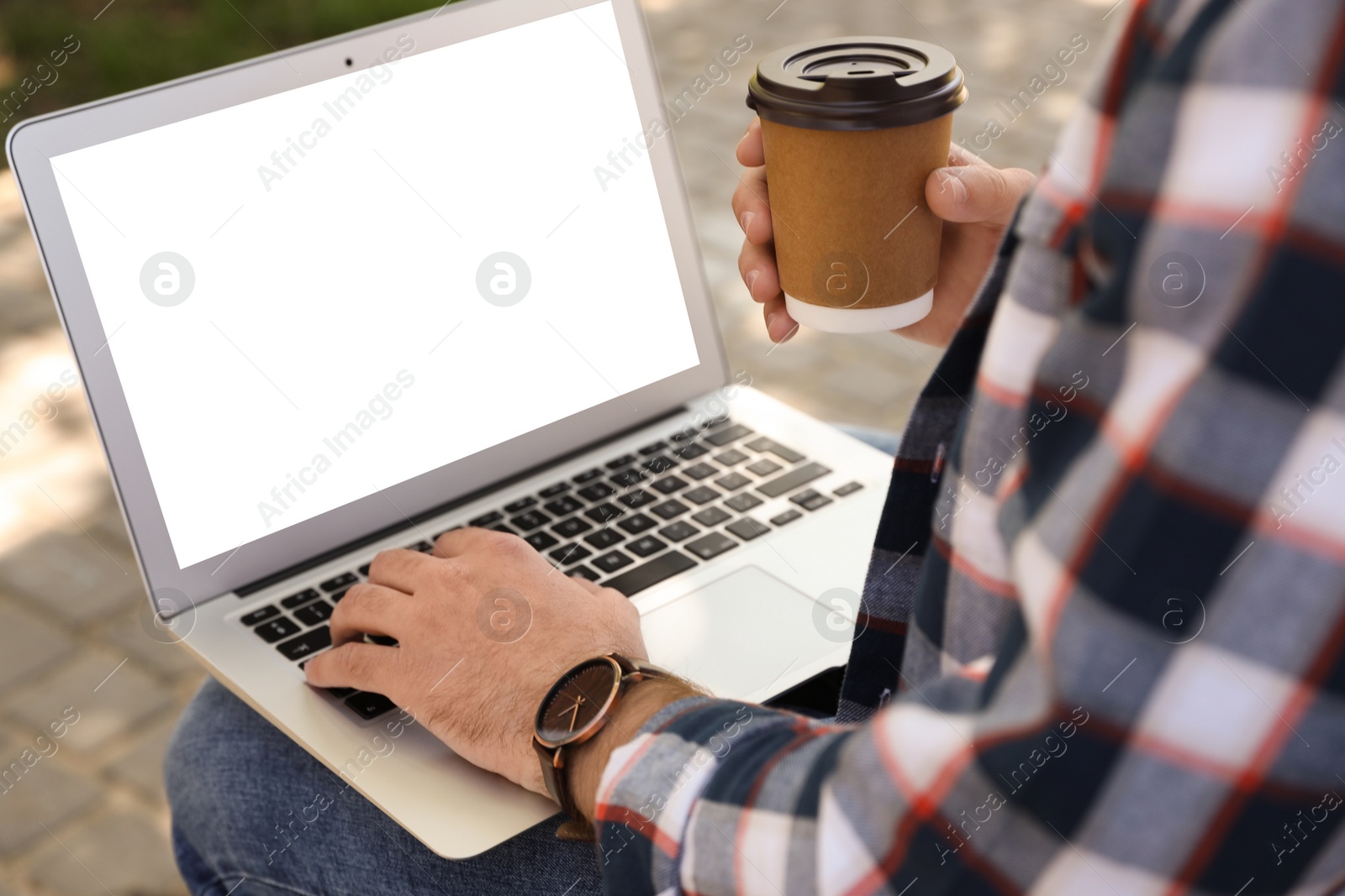 Image of Young man using modern computer outdoors, closeup. Space for design