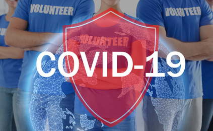 Image of Volunteers uniting to help during COVID-19 outbreak, closeup. Shield and world globe illustrations against group of people
