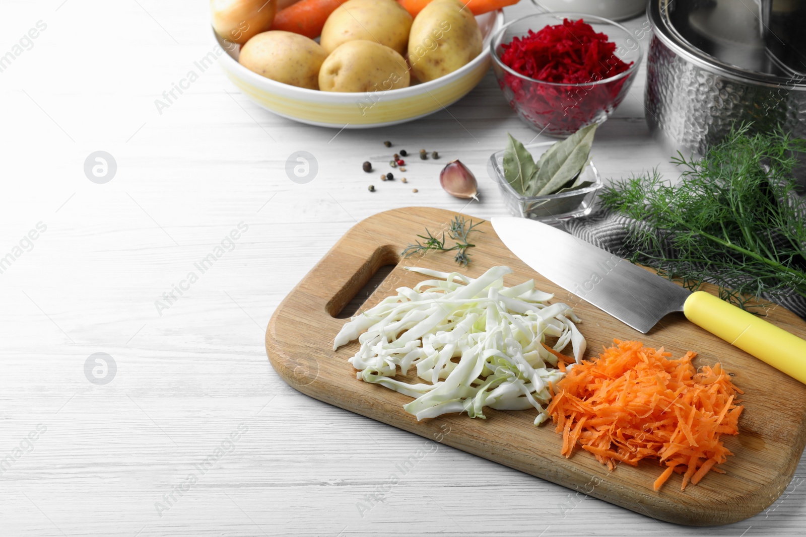 Photo of Fresh borscht ingredients on white wooden table, space for text