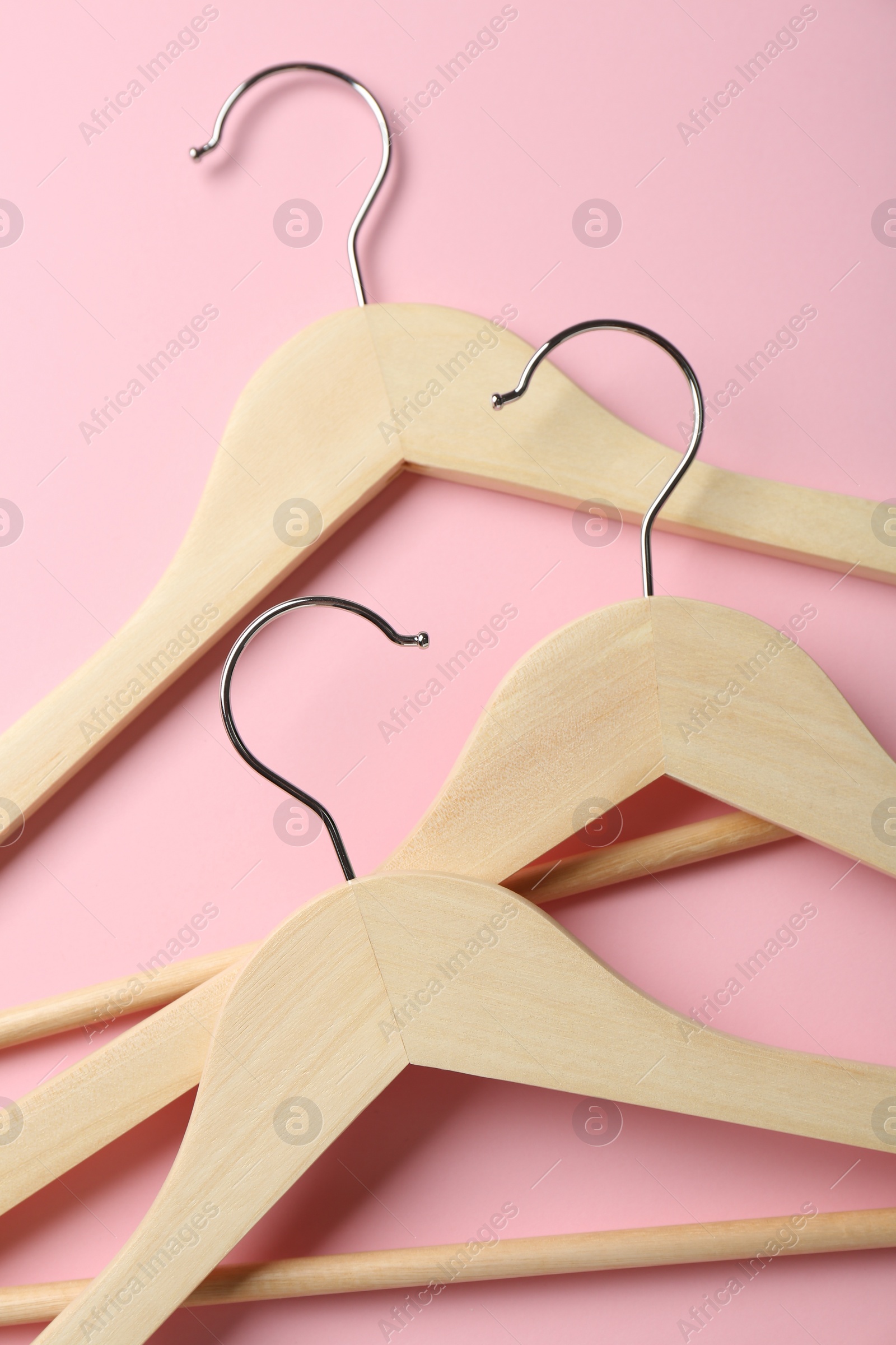 Photo of Wooden hangers on pink background, top view