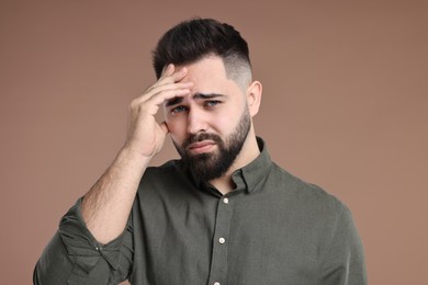 Photo of Portrait of sad man on brown background