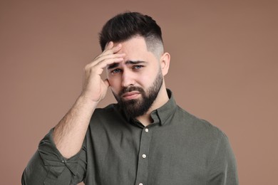 Portrait of sad man on brown background