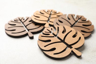 Photo of Leaf shaped wooden cup coasters on white table
