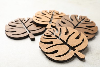 Leaf shaped wooden cup coasters on white table