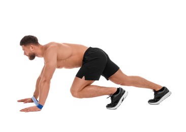 Young man exercising with elastic resistance band on white background