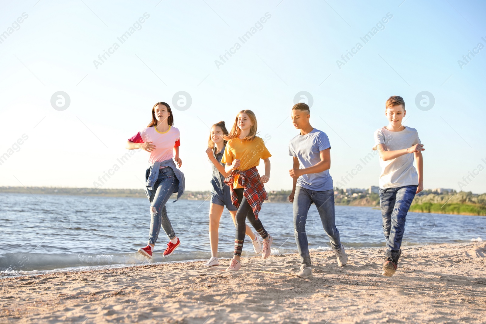 Photo of Group of children running on beach. Summer camp