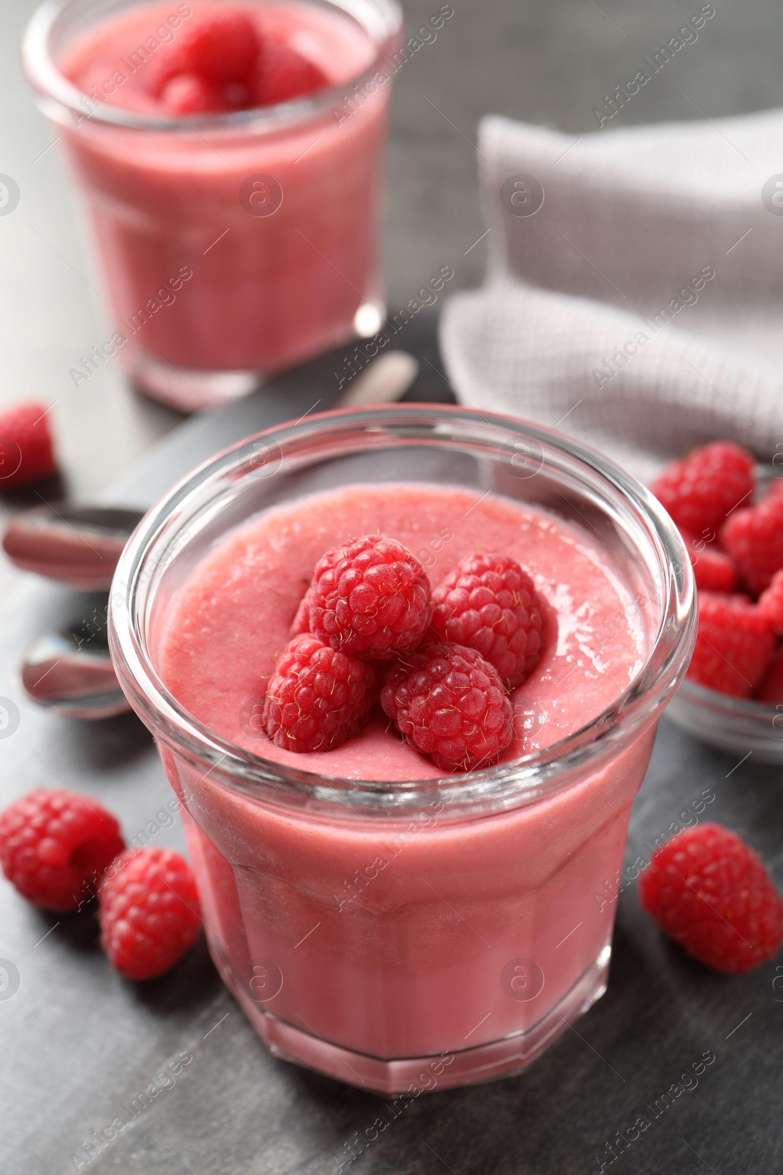 Photo of Delicious raspberry mousse served on grey table