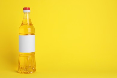 Photo of Bottle of cooking oil on yellow background. Space for text